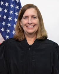 Judge Erica S. Beardsley, a smiling white woman with blonde hair wearing a judge's black robe