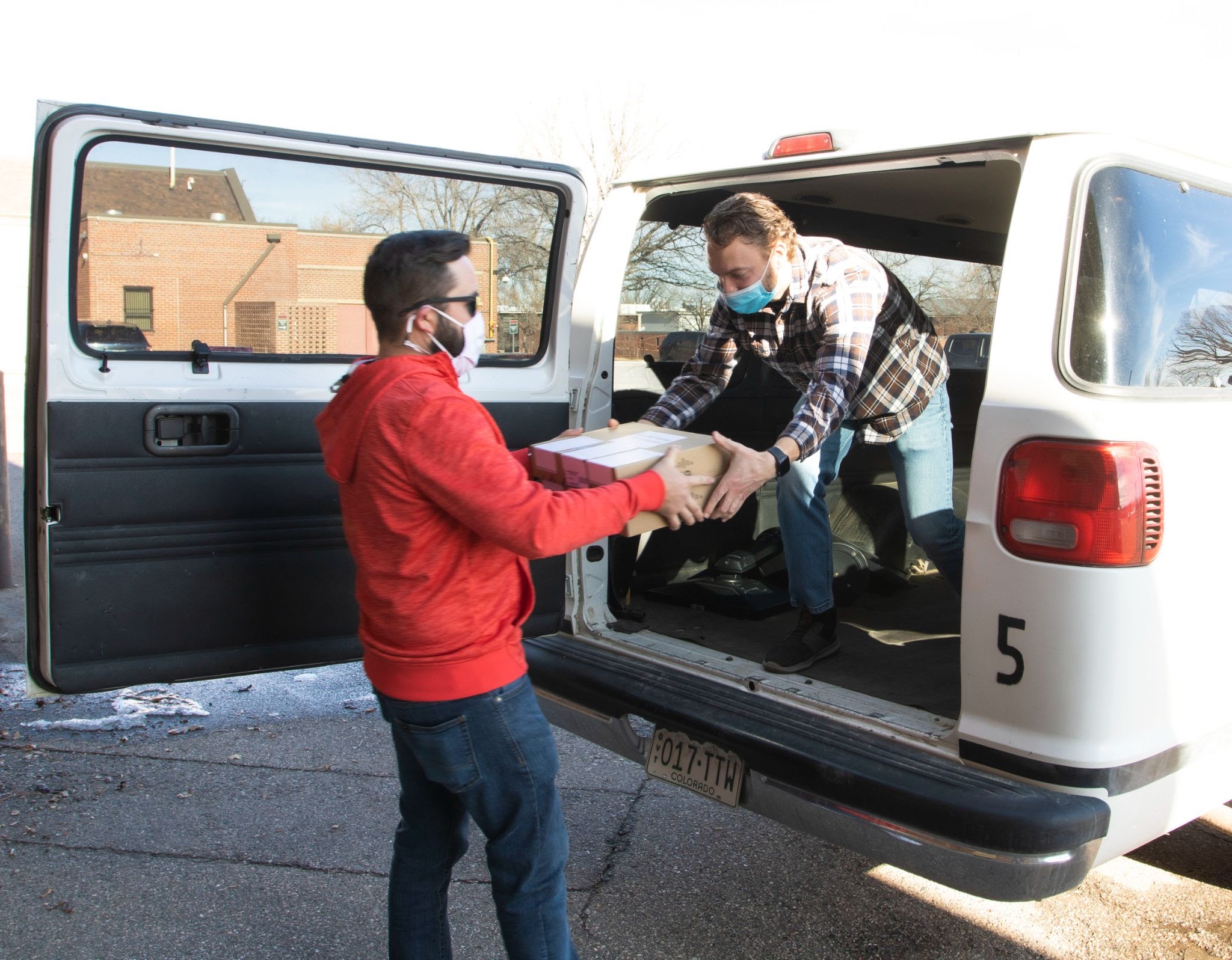 Two people loading computers onto an Eaton School District van