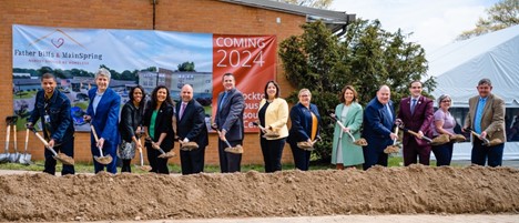 people standing with shovels breaking ground