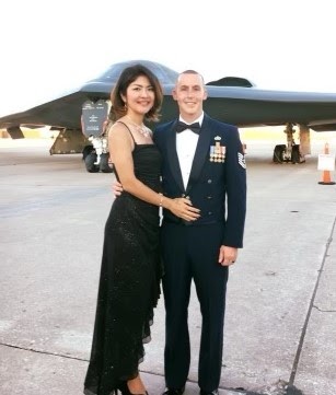 Two people stand near an airplane outdoors.