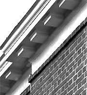 close up, exterior of building showing square blocks extending from the bottom of the roof eaves