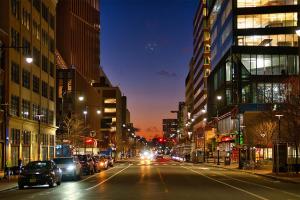  A city road at night with lights and cars and buildings on both sides