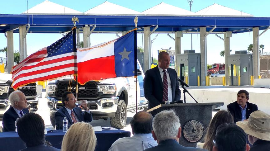 GSA PBS Deputy Regional Commissioner Jared Bradley stands behind a podium with the Texas and United States flags in the background.