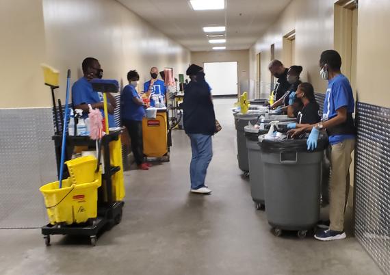 Janitorial staff at the Richard Bolling Federal Building wearing gloves and face masks prepare to clean the building.
