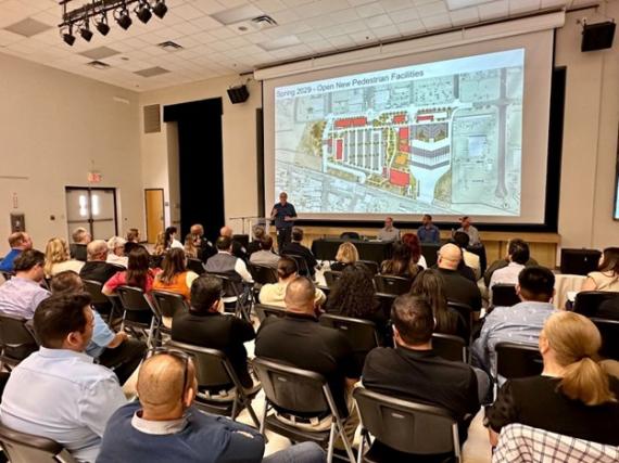 A community event held at Calexico and San Luis. The event photo shows the back of indivdiuals as they are looking at a presentation 