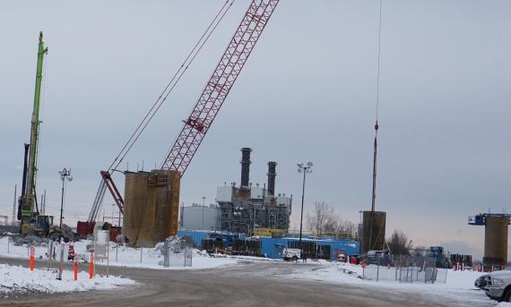 Long shot of high-rise crane and bridge supports under construction taken from the U.S. side