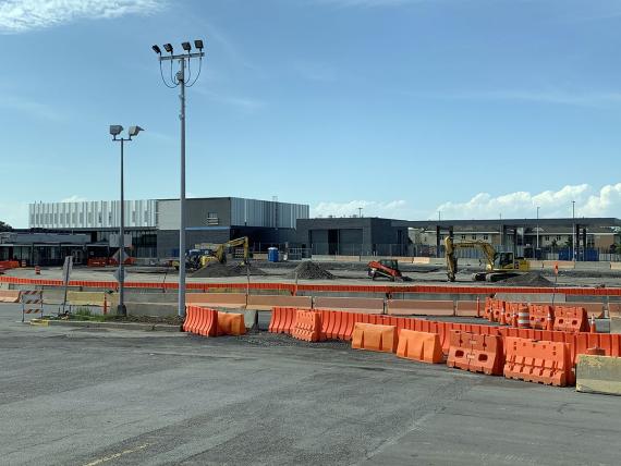 Construction zone with orange barriers in front of a block-shaped building