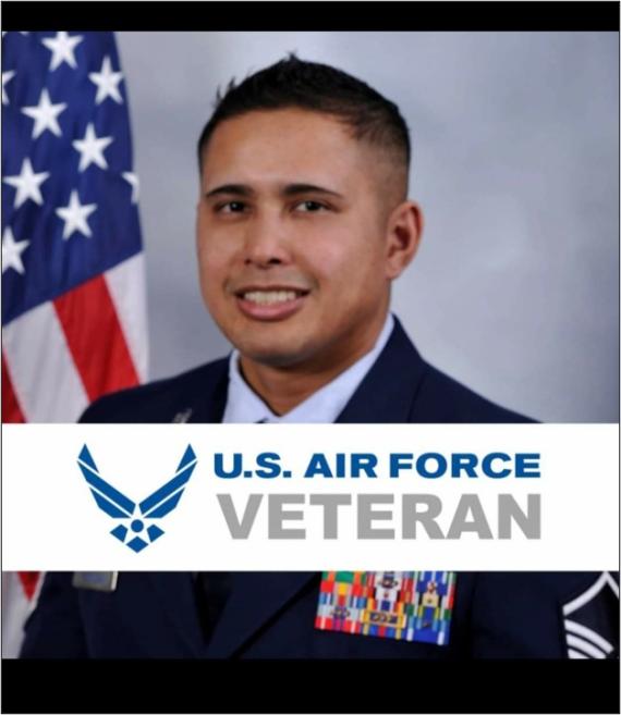 Victor Vorgsam, smiling, wearing a U.S. Air Force uniform and posing in front of a U.S. flag. A white banner across the picture reads: U.S. Air Force Veteran.