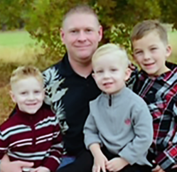 An adult and three children outside.