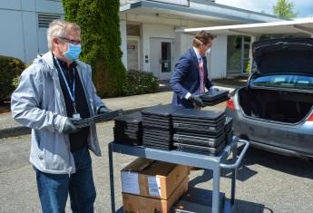 Roy Atwood, GSA Northwest/Arctic Region Regional Administrator assists Winlock School Superintendent Garry Cameron with loading 