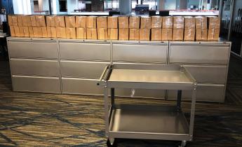 Cardboard boxes stacked two high and 20 across on top of lateral file cabinets.