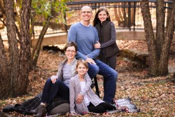 A family of four outdoors in the fall.