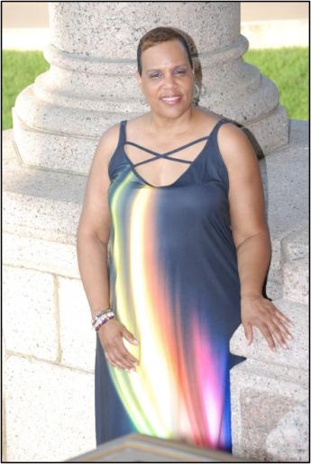 Janice Butler leaning against stone pillars.