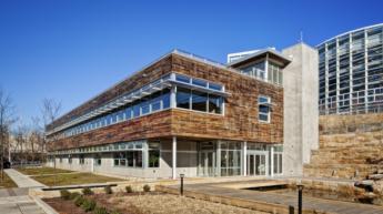 The Phipps Center. A modern, long two-story building with cement on the first floor and wood on the second. Windows run the entire length.