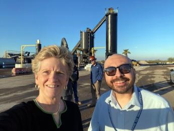 Smiling woman and man taking a selfie in front of a construction structure