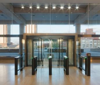 Photo of a building entrance showing an airlock - two sets of glass doors with space in between.