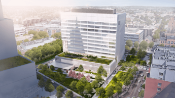 A white and glass building surrounded by trees and grass in the middle of a cityscape