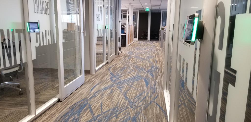 Small (huddle) rooms with sliding glass doors and digital displays that have been installed lower than they were previously posi